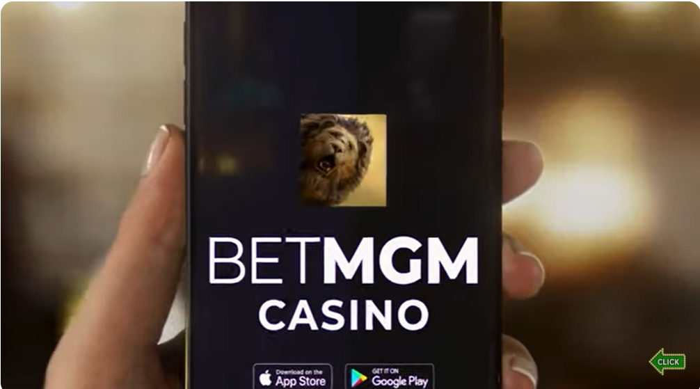 A hand holding a smartphone displaying the BetMGM Casino app interface, featuring a lion logo, "BETMGM CASINO" text, and download buttons for the App Store and Google Play, with a "Click" prompt.